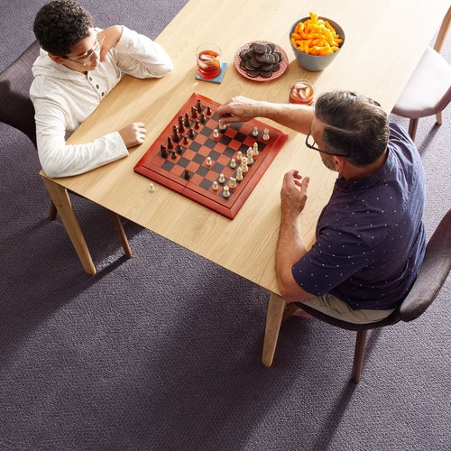 A dad is playing chess with his son from Young's Interiors & Flooring in Ford City
